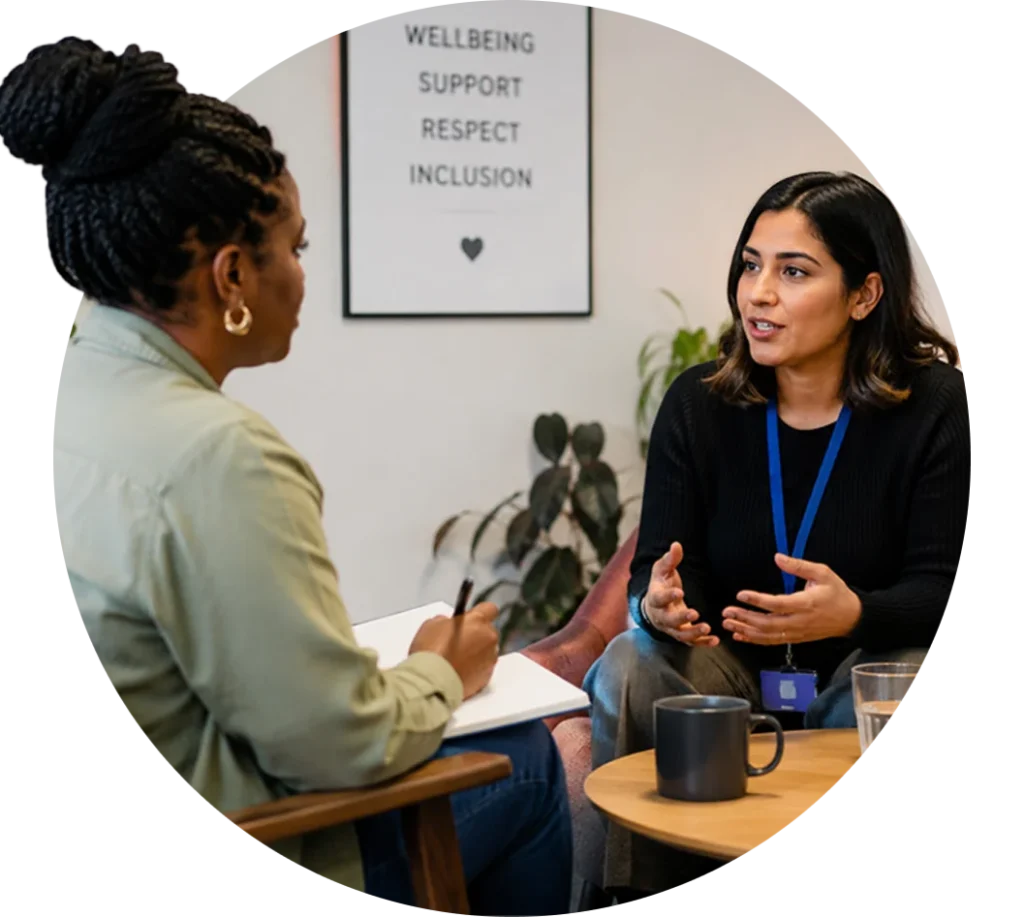 Two women talking across a desk in an office